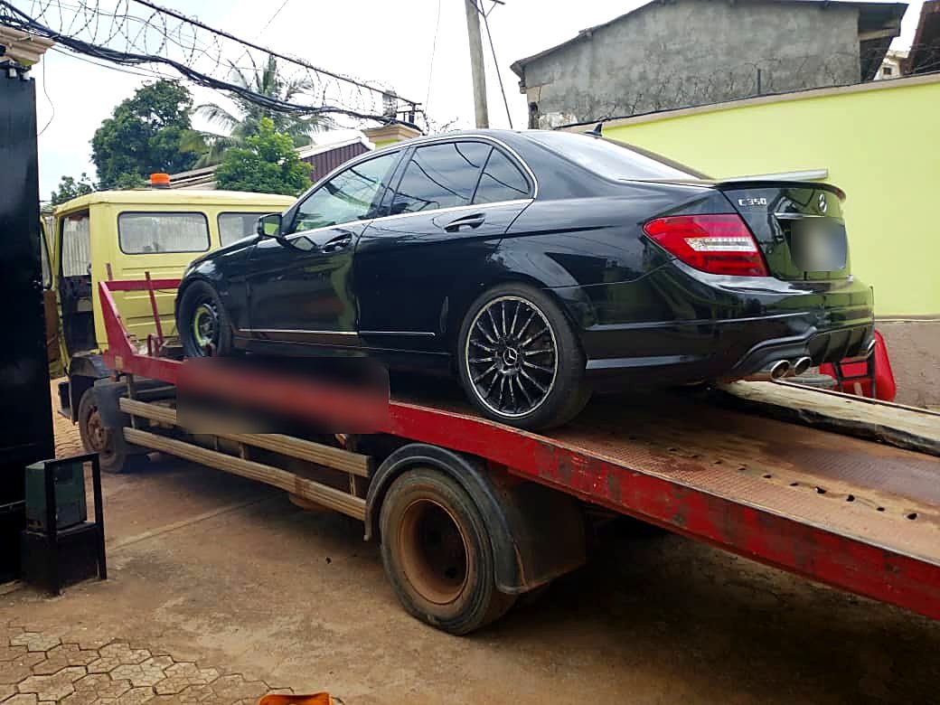Mercedes Classe C 350 noire arrimée sur le plateau d'une dépanneuse Remorquage237 à Yaoundé
